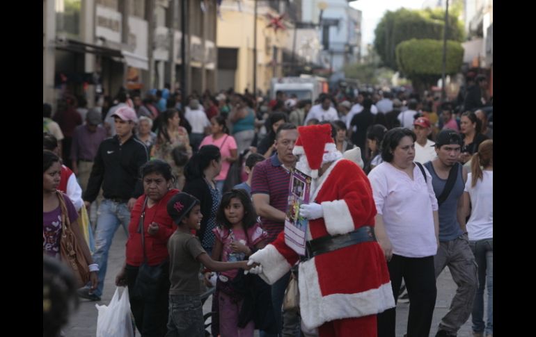 Santa se abre paso para saludar a los más pequeños entre la multitud que cubre las calles del Centro Histórico. EL INFORMADOR / R. Tamayo