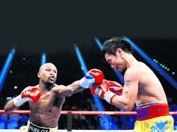 ¿La pelea del siglo? Floyd Mayweather Jr. golpea a Manny Pacquiao durante la pelea de unificación en Las Vegas. AFP /