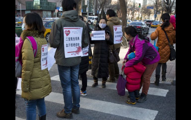 Padres de hijos no registrados protestan ante la puerta de las oficinas nacionales de planificación nacional. AP / N. Han Guan