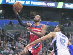 El base John Wall (Izq.) aportó 24 puntos y entregó 10 asistencias para los Wizards de Washington. AP /