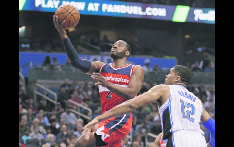 El base John Wall (Izq.) aportó 24 puntos y entregó 10 asistencias para los Wizards de Washington. AP /