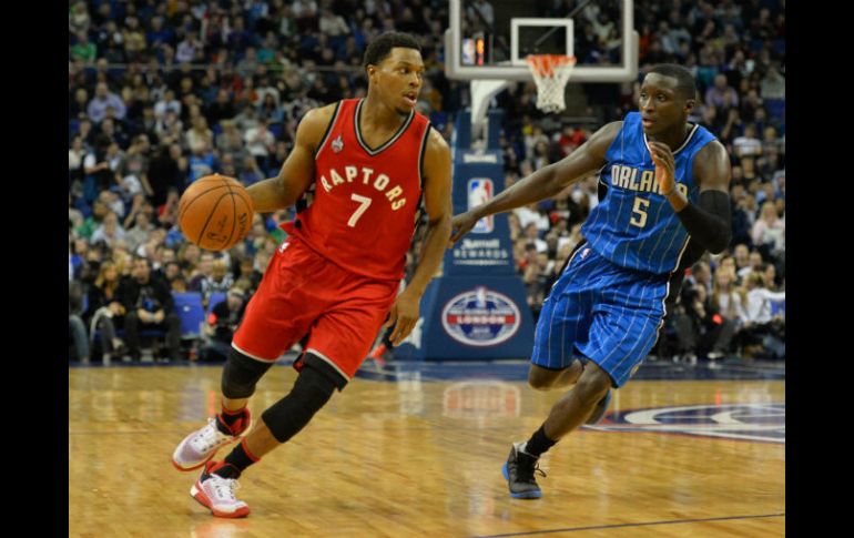 Kyle Lowry (izq.) lleva el balón durante el juego entre los Raptors y Orlando celebrado ayer en Londres. AFP / G. Kirk