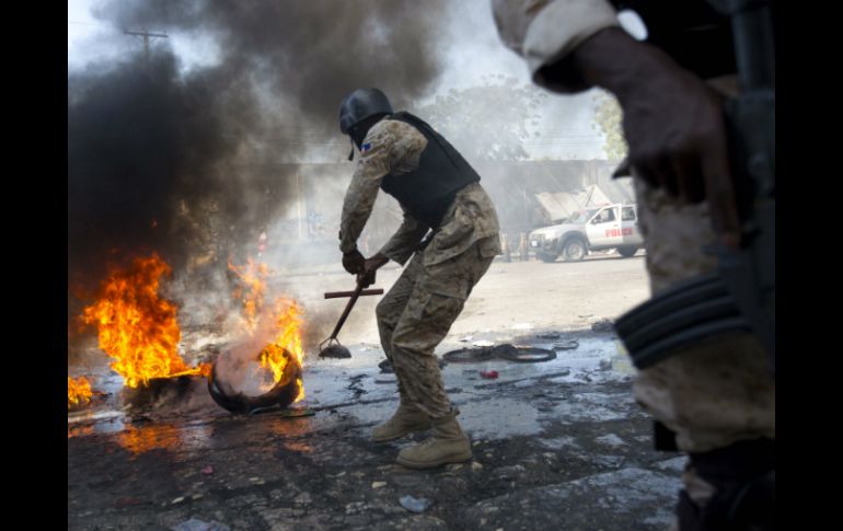 Opositores bloquearon las calles con contenedores de basura, piedras y neumáticos en llamas. AP / D. Nalio Chery