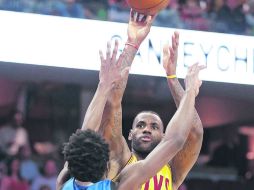 La figura. LeBron James realiza un tiro al aro ante la marca de Andrew Wiggins. AP / T. Dejak