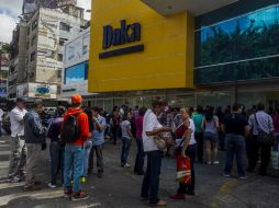 Algunas personas esperan horas en las filas para comprar su despensa. EFE / ARCHIVO