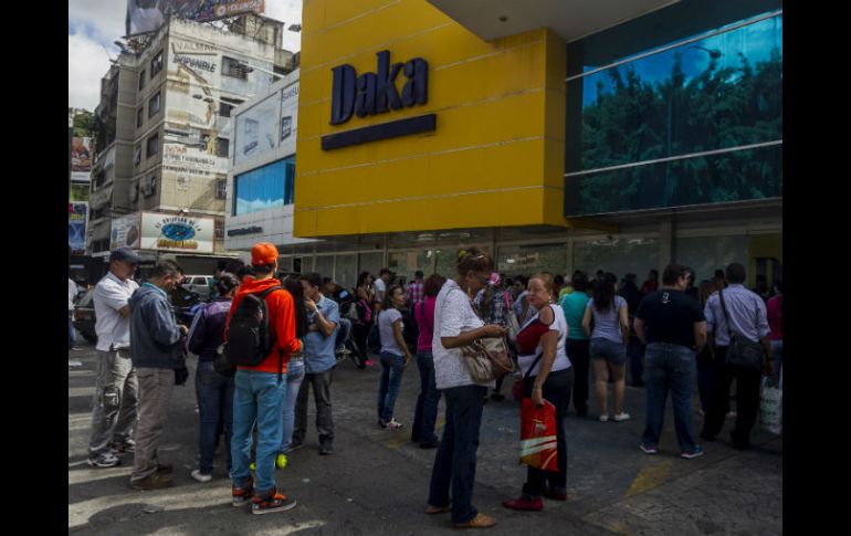 Algunas personas esperan horas en las filas para comprar su despensa. EFE / ARCHIVO