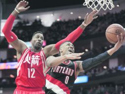 Damian Lillard (#0) de los Trail Blazers de Portland lanza el esférico a la canasta ante la marca de Dwight Howard (“12). AP /  P. Sullivan