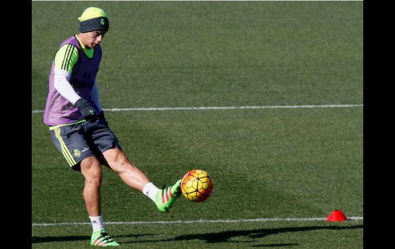 El centrocampista del Real Madrid James Rodríguez toca el balón, durante el entrenamiento del equipo hoy en Valdebebas. EFE / J. Martin