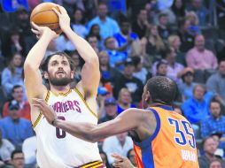 El jugador de los Cavaliers de Cleveland, Kevin Love (izq.), realiza un tiro a la canasta para conseguir dos de sus 29 puntos. AP / A. Adams