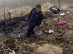 Un agente de policía busca los cuerpos de las víctimas del accidente de avión de la compañía Tara Air. EFE / S. Gautam