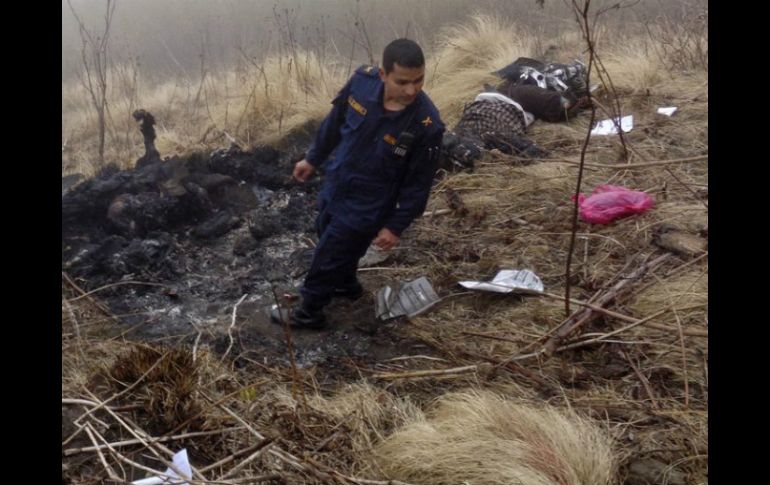 Un agente de policía busca los cuerpos de las víctimas del accidente de avión de la compañía Tara Air. EFE / S. Gautam