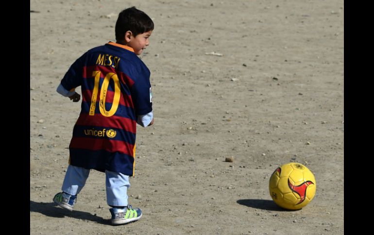 Murtaza Ahmadi posa con una camiseta de su ídolo en la oficina de UNICEF en Kabul. AFP / W. Kohsar