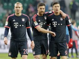 Sebastian Rode (i), Xabi Alonso y Robert Lewandowski (d); este último, anotó uno de los dos goles que le dieron el triunfo al Bayern. AP / M. Sohn