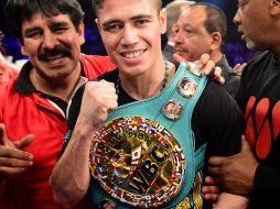 'Cuatito' posa con su cinturón de campeón en la categoría de peso supergallo tras el combate. AFP / H. How