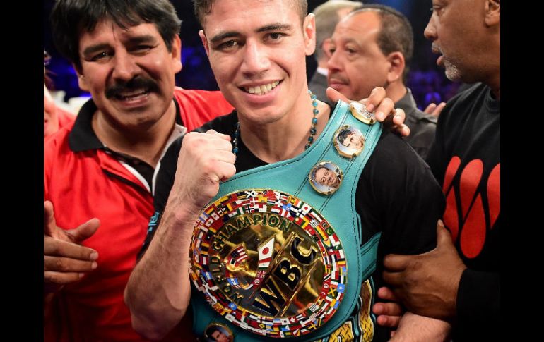 'Cuatito' posa con su cinturón de campeón en la categoría de peso supergallo tras el combate. AFP / H. How