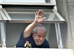 El ex presidente Lula da Silva saluda a simpatizantes desde una ventana de la sede el Partido de los Trabajadores. AFP / N. Almeida