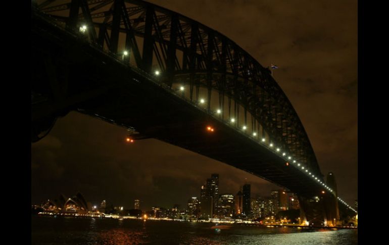 La Ópera de Sydney, un inmueble normalmente muy iluminado, apagó sus luces junto con el puente del puerto de la ciudad (foto). EFE / S. Mooy