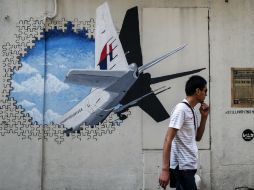 Un hombre camina junto a un mural del vuelo desaparecido de Malaysia Airlines a las afueras de Kuala Lumpur. EFE / ARCHIVO