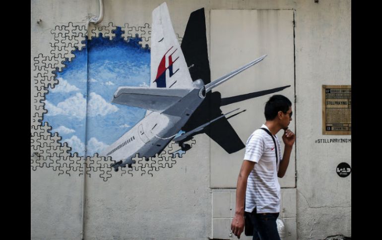 Un hombre camina junto a un mural del vuelo desaparecido de Malaysia Airlines a las afueras de Kuala Lumpur. EFE / ARCHIVO