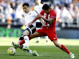 El centrocampista del Valencia y el del Sevilla pelean un balón durante el partido. EFE / K. Försterling