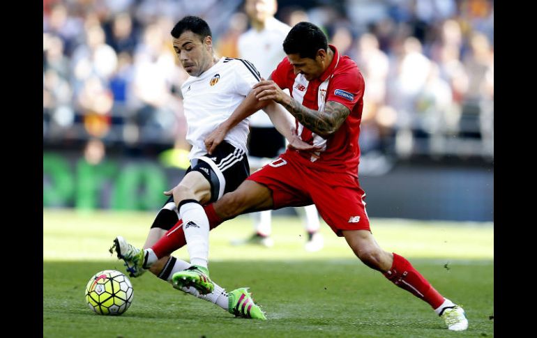 El centrocampista del Valencia y el del Sevilla pelean un balón durante el partido. EFE / K. Försterling