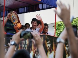 Manny Pacquiao saluda a varios fanáticos, quienes salieron a las calles para vitorearlo. AP / A. Favila