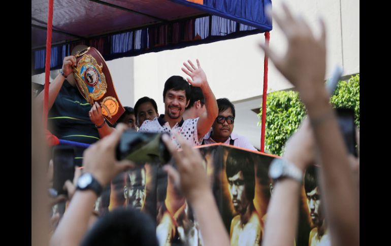 Manny Pacquiao saluda a varios fanáticos, quienes salieron a las calles para vitorearlo. AP / A. Favila