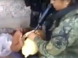 Además de colocar una bolsa de plástico en la cabeza de la mujer, el video muestra como una soldado la encañona. YOUTUBE / Manuel Feregrino