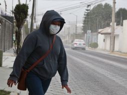 Una mujer, en Puebla, usa un cubrebocas para protegerse de la ceniza emanada del volcán Popocatépetl. AFP / J. Castañares