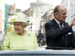 La reina junto a su esposo saludan al público durante el desfile de celebración por su cumpleaños 90. EFE / F. Arrizabalaga