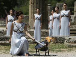 La sacerdotisa y sus vestales capturan los rayos del sol en un espejo parabólico ante el templo de Hera en Olimpia. AP / T. Stavrakis