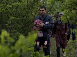 Salían de un bosque después de un periplo de tres horas desde Idomeni, donde cruzaron un río. AFP / J. Klamar