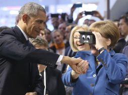 Angela Merkel (d), utiliza unas gafas de realidad virtual junto al presidente de Estados Unidos, Barack Obama. EFE / C. Charisius