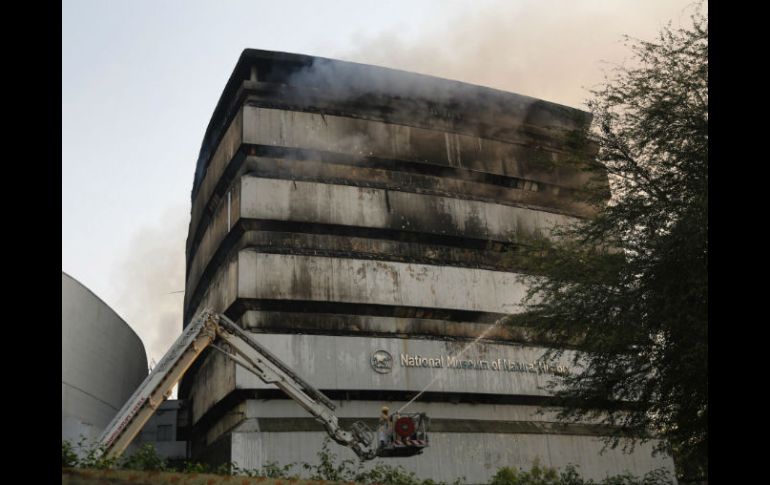 Bomberos trabajan arduamente para extinguir el incendio, que acabó con todo el edificio. EFE / R. Gupta