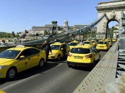 Taxistas forman una línea con sus vehículos en el Puente de las Cadenas durante la manifestación contra Uber. EFE / N. Bruzak