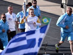 Entrada de la antorcha olímpica al estadio de Panathinaicó antes de la ceremonia de entrega. AFP / L. Gouliamaki