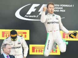 Nico Rosberg celebra su primer lugar del podio en Rusia ante la mirada de Vladimir Putin. AP /