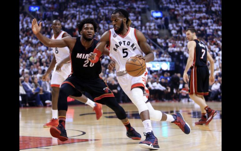 DeMarre Carroll, (#5) de los Raptors, supera Justice Winslow, de Miami. El jugador del equipo canadiense se despachó con 21 puntos. AFP / V. Ridley