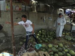 Vendedores tratan de recuperar la mayor cantidad de mercancía posible, ya que con la explosión varios puestos se incendiaron. AP / K. Mohammed