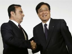 El presidente de Nissan, Carlos Ghosn, le da la mano a su homónimo de Mitsubishi, Osamu Masuko tras dar a conocer el acuerdo. AP / E. Hoshiko