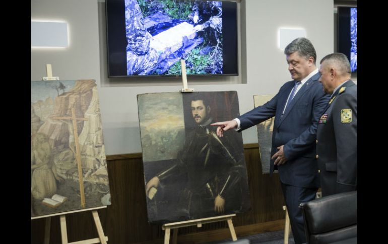 Petro Poroshenko, presidente de Ucrania, mira las pinturas recuperadas. AP / M. Palinchak