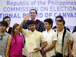 Manny Pacquiao (c), junto a su esposa, Jinky (2i), sostiene su certificado de senador durante la ceremonia. EFE / F. Malasig