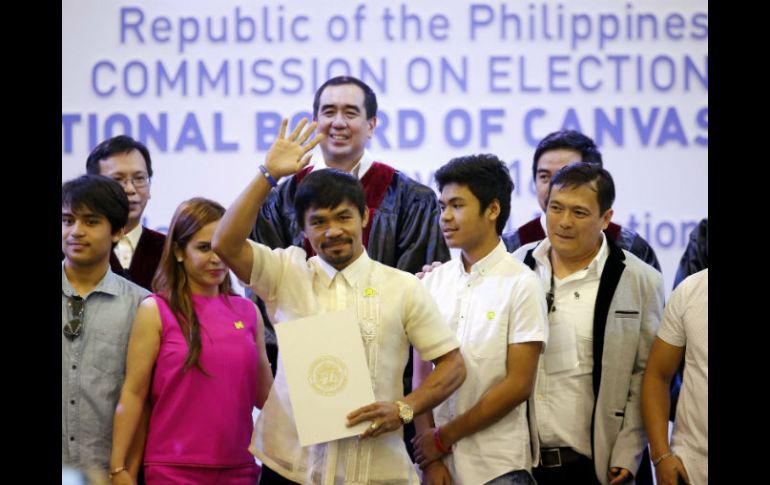 Manny Pacquiao (c), junto a su esposa, Jinky (2i), sostiene su certificado de senador durante la ceremonia. EFE / F. Malasig