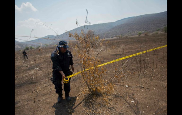 Un policía acordona parte del paraje donde se hallaron los restos. AFP / P. Pardo