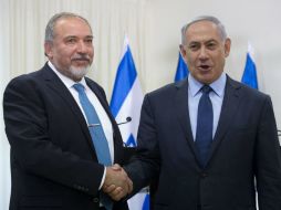 Benjamin Netanyahu (d) estrecha la mano de Avigdor Lieberman, ahora minsitro de Defensa. EFE / A. Sultan