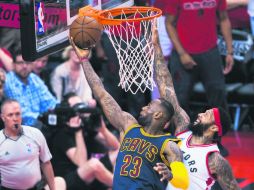 La estrella de los Cavaliers, LeBron James (23) intenta encestar ante la marca de James Johnson, de los Raptors. AFP / N. Denette