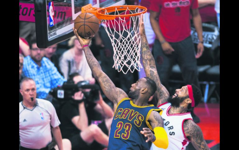 La estrella de los Cavaliers, LeBron James (23) intenta encestar ante la marca de James Johnson, de los Raptors. AFP / N. Denette