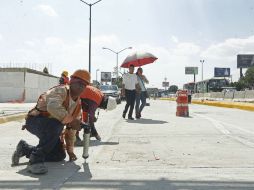 Trabajadores hacen los arreglos finales a los carriles laterales. EL INFORMADOR / E. Barrera