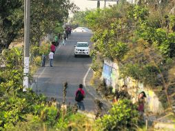 Peatones que transitan por una vía deben esquivar los autos, pues en la zona no existen banquetas ni puentes. EL INFORMADOR / R. Tamayo