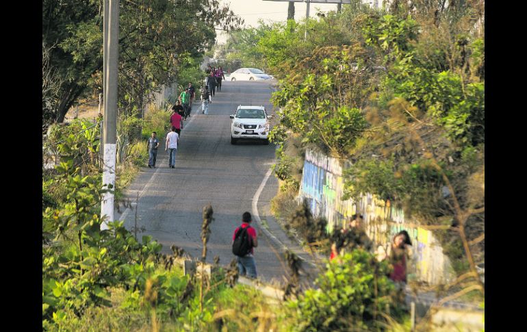 Peatones que transitan por una vía deben esquivar los autos, pues en la zona no existen banquetas ni puentes. EL INFORMADOR / R. Tamayo